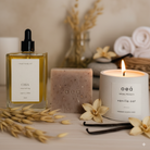 Eine Flasche Koerper Oel, eine Seife und eine Kerze mit Vanille Duft